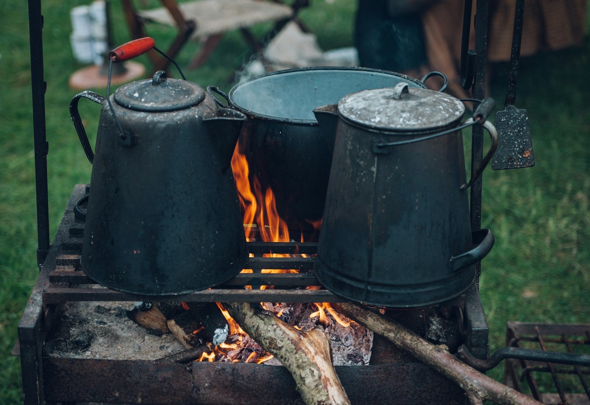 kettles and pot on top of fire